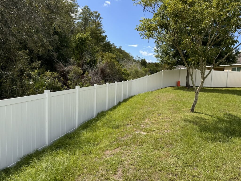 White vinyl privacy fence in a residential backyard