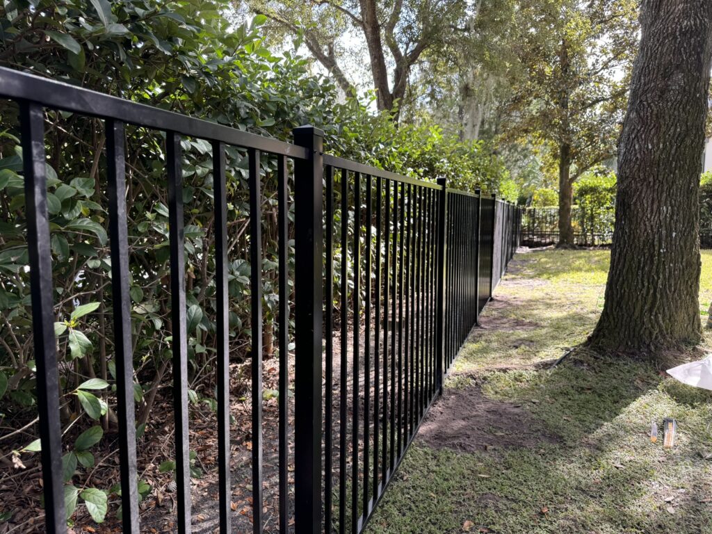Flat-top aluminum fence enclosing a front yard
